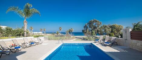 Een verwarmd zwembad, ligstoelen bij het zwembad