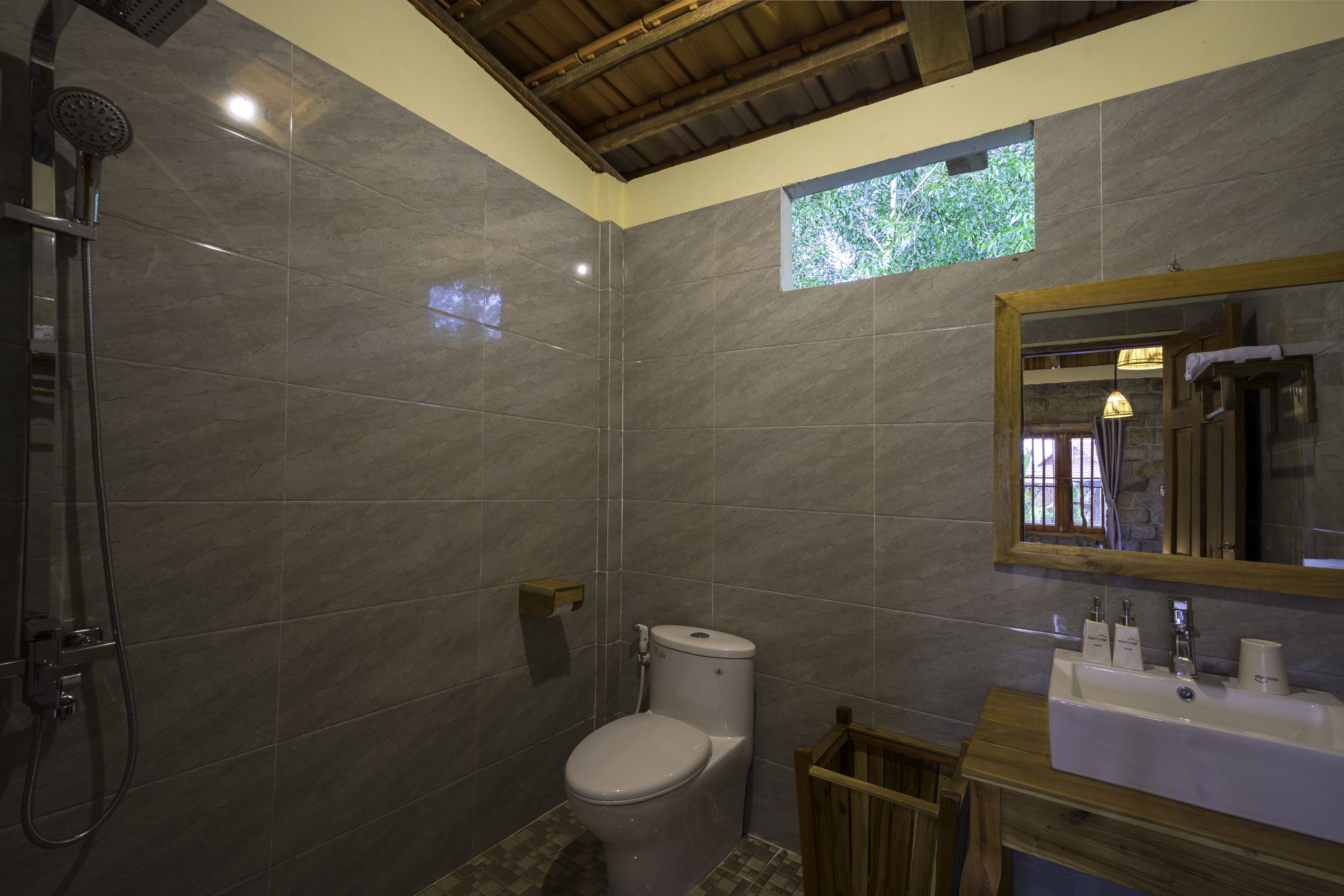 Een badkamer met douche, toilet, wastafel en spiegel.