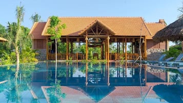 Una piscina al aire libre, camas de piscina gratis, sombrillas