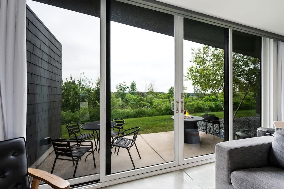 A modern patio with a glass door leading to an outdoor area.