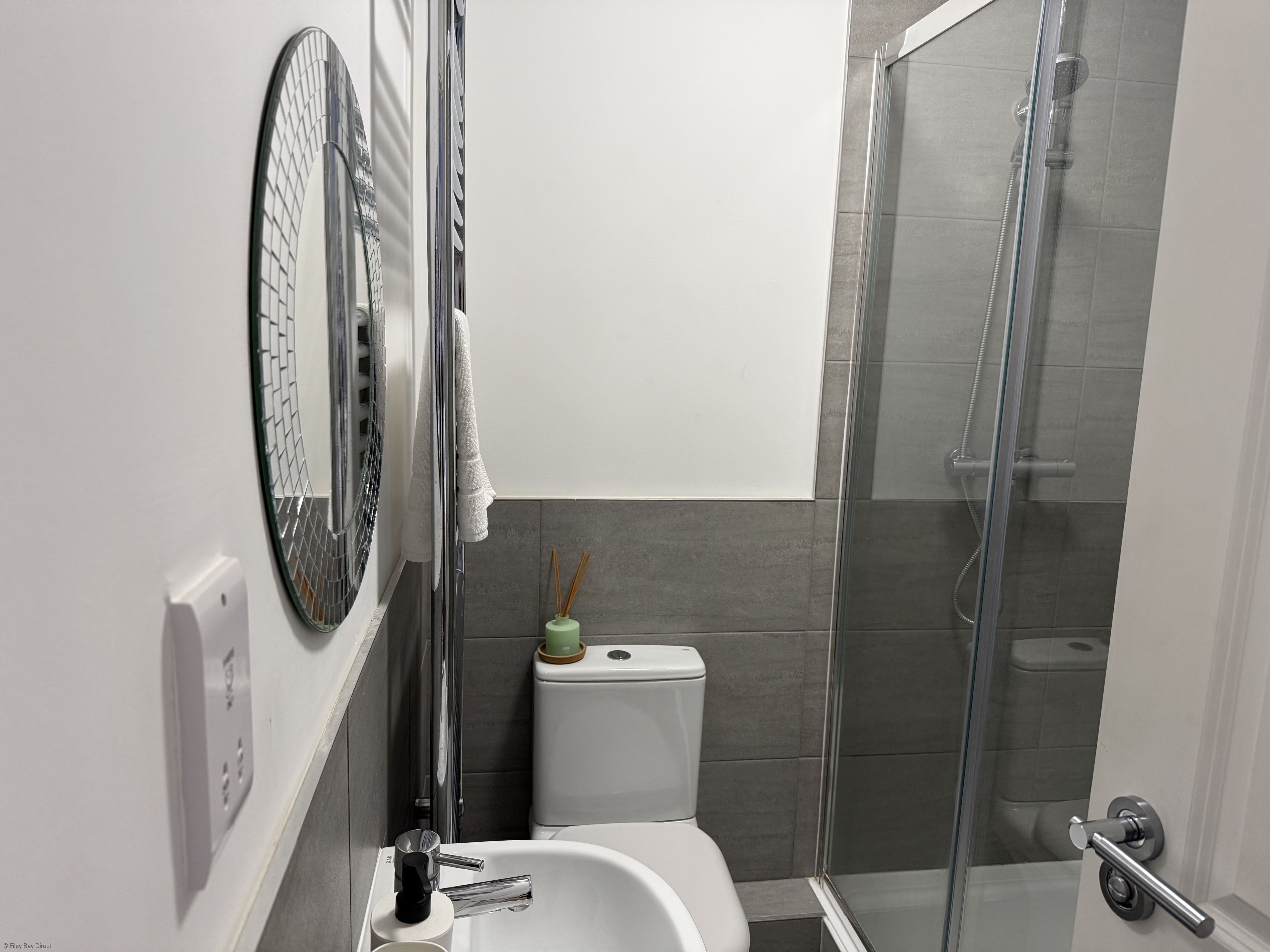 Um banheiro moderno com box de vidro, vaso sanitário branco e banheira.