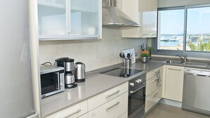Une cuisine moderne avec vue sur le port de plaisance, des appareils en acier inoxydable et une fenêtre offrant une belle perspective.