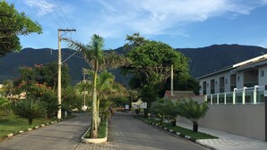 A paved pathway leading to a building with a mountain backdrop.