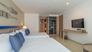 A hotel room with two beds, a TV, a desk, and a wardrobe.