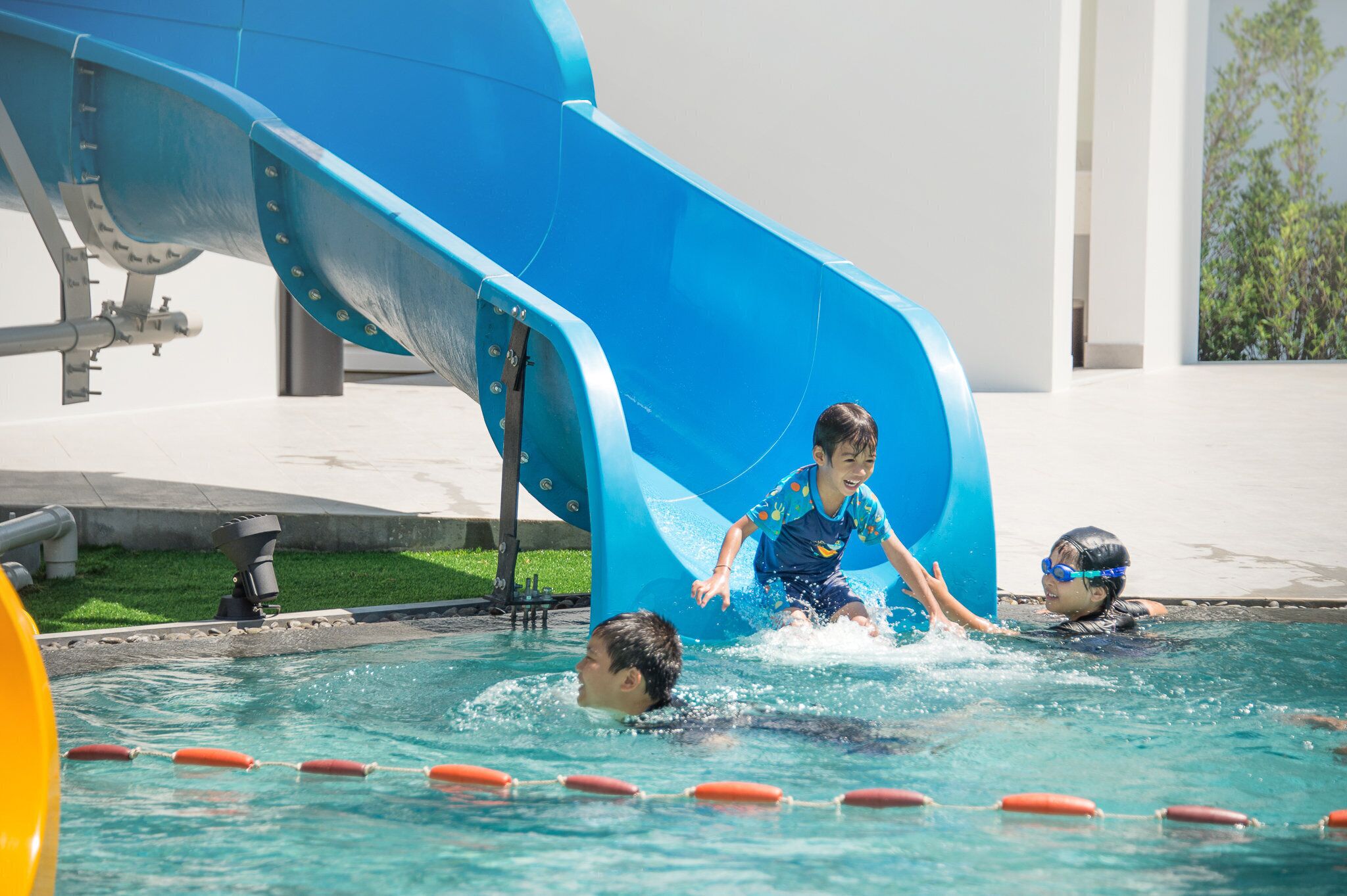 A swimming pool with a blue slide and lane dividers.