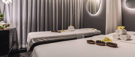 A hotel room with two beds, a mirror, and a curtain.