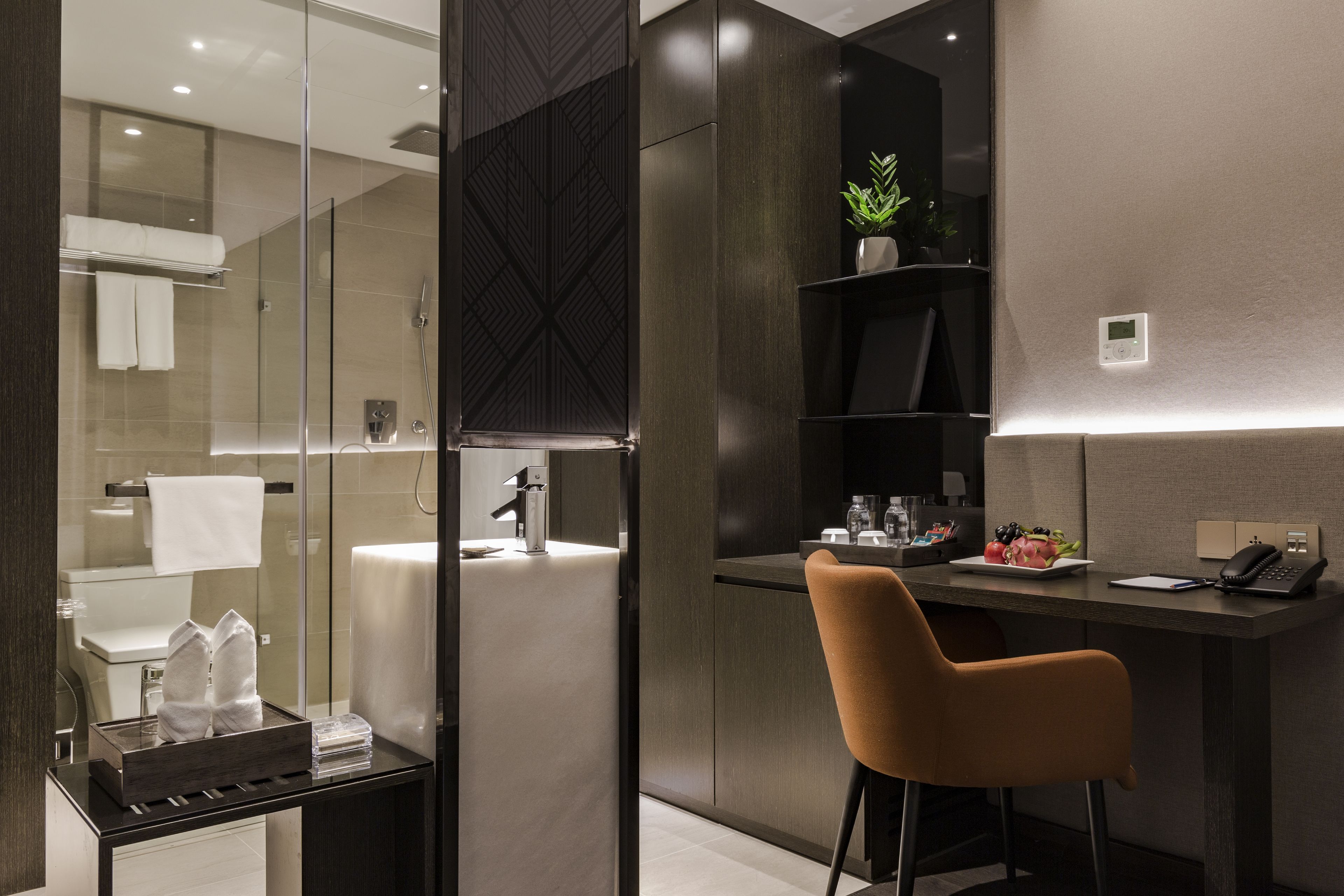 A modern bathroom with a glass shower enclosure, a sink, and a towel rack.