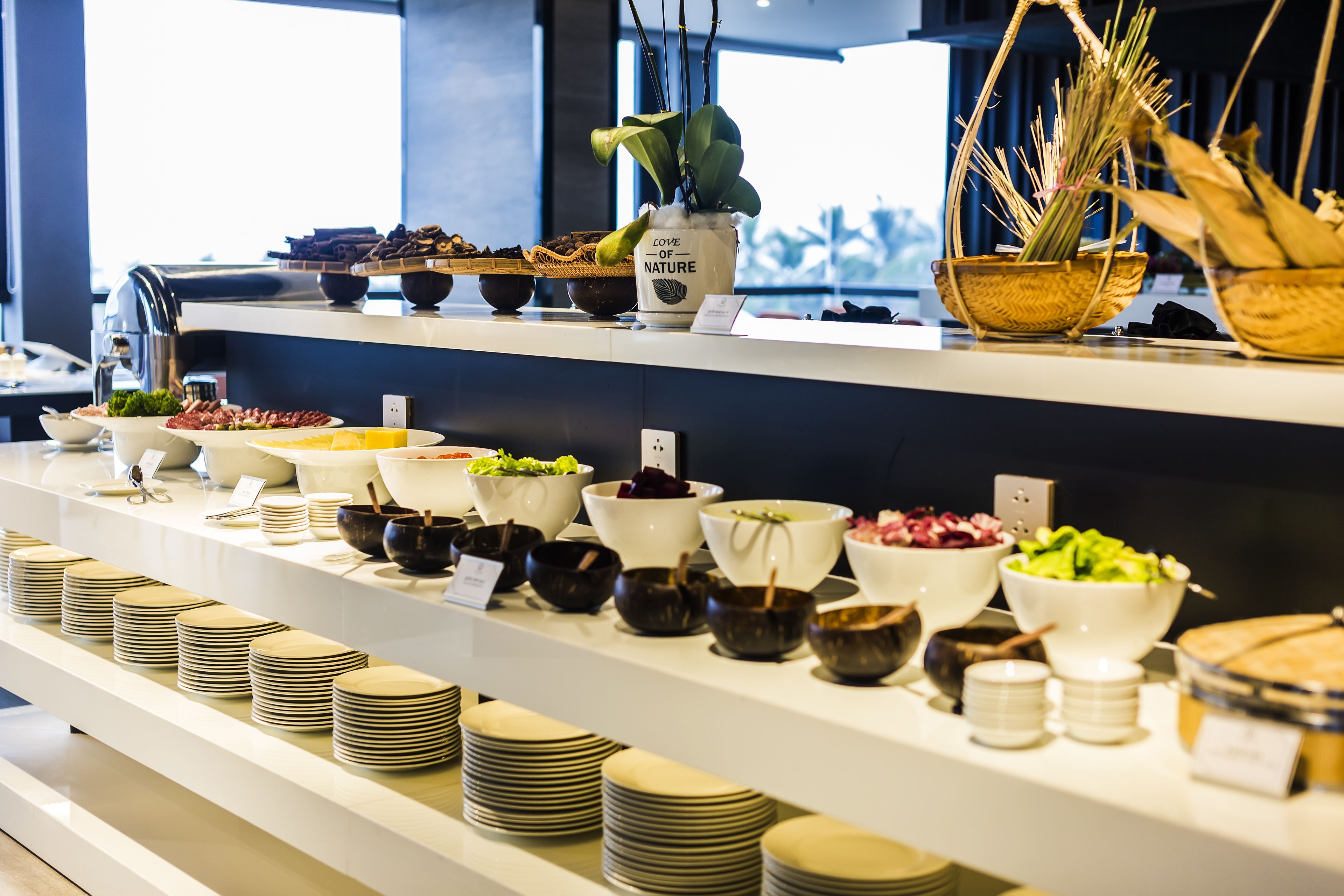 A buffet setup with various dishes and bowls on shelves.