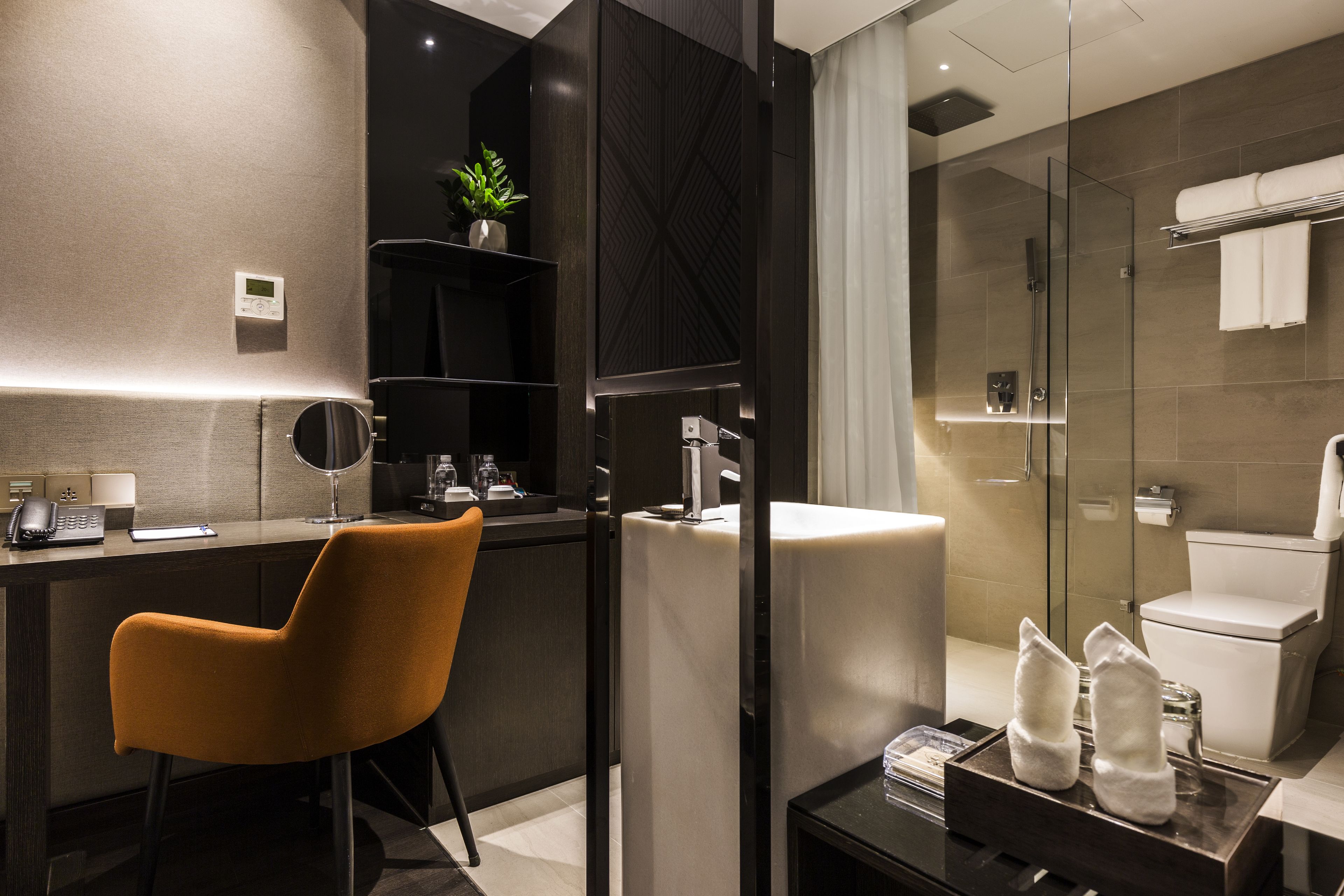Une salle de bain moderne avec une douche à parois de verre, un lavabo blanc et un porte-serviettes.