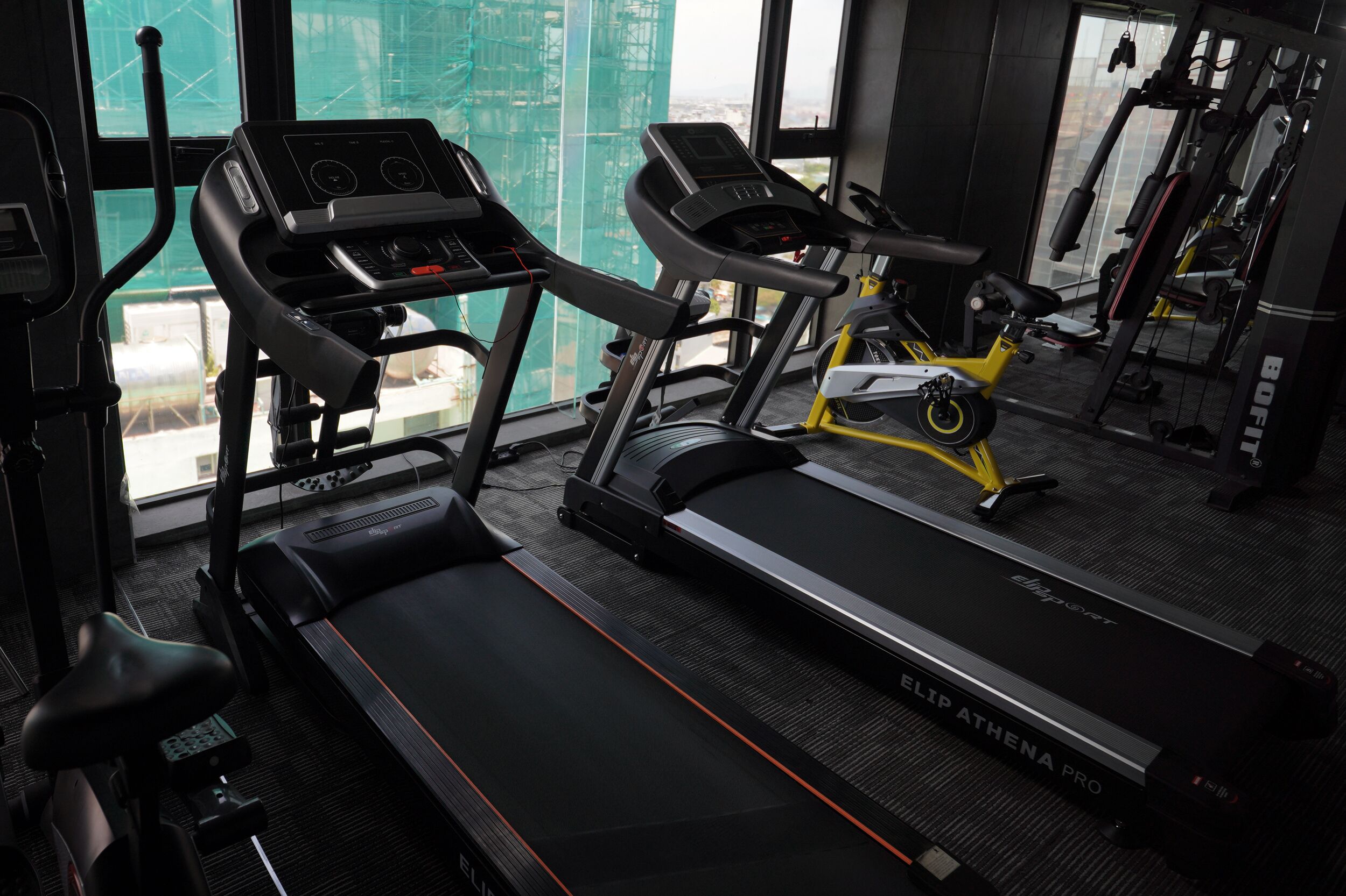 A gym with treadmills, an elliptical, and a stationary bike.