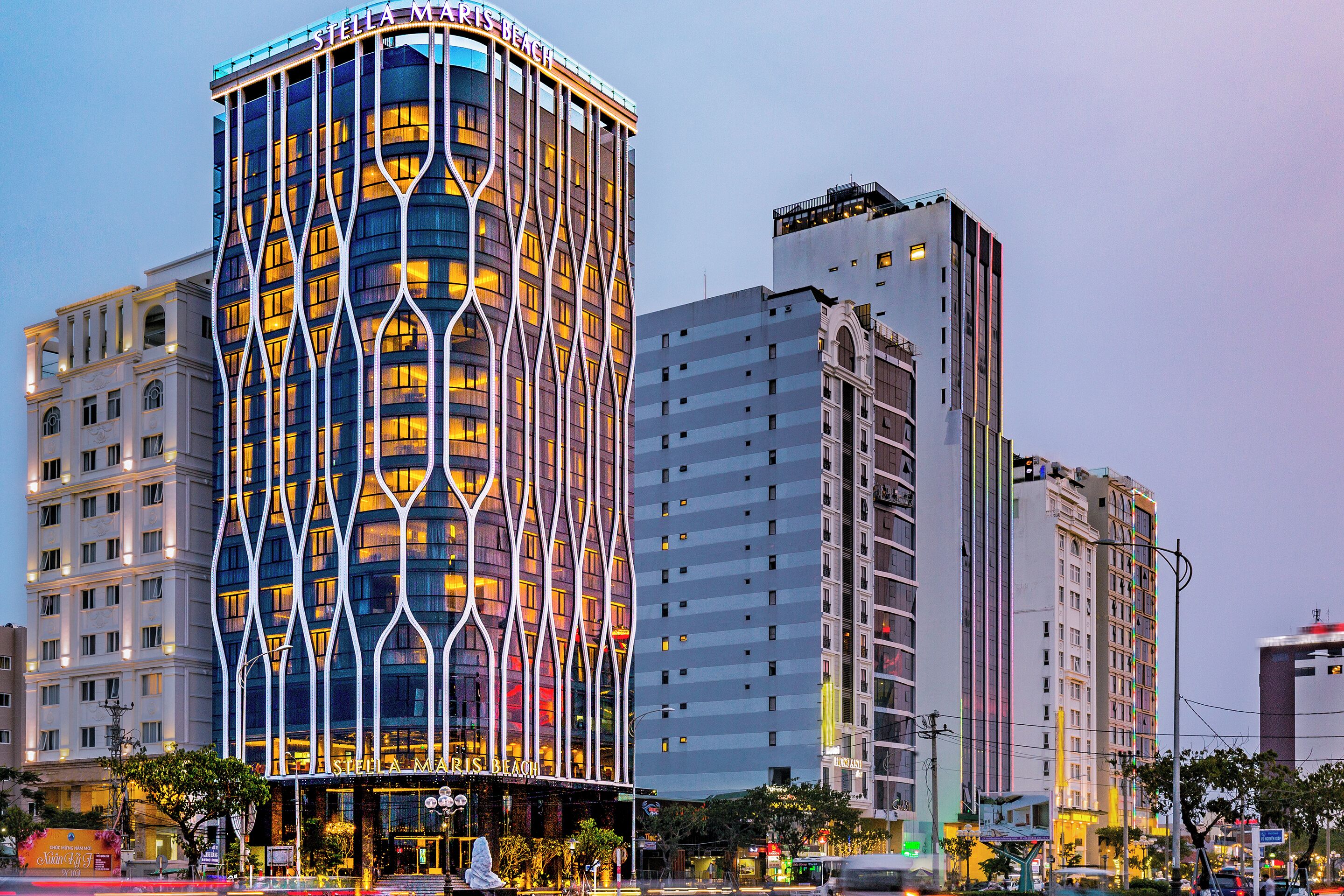 A multi-story hotel with a distinctive facade featuring vertical lines and illuminated windows.