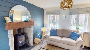 Una sala de estar acogedora con chimenea, un sofá y un espejo grande.