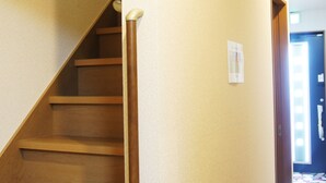 Un escalier avec des marches en bois et une rampe, menant à l’étage supérieur.