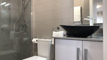 Een bad/douchecombinatie, een haardroger, handdoeken, shampoo