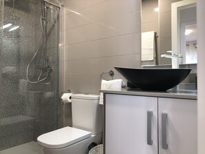 Een bad/douchecombinatie, een haardroger, handdoeken, shampoo