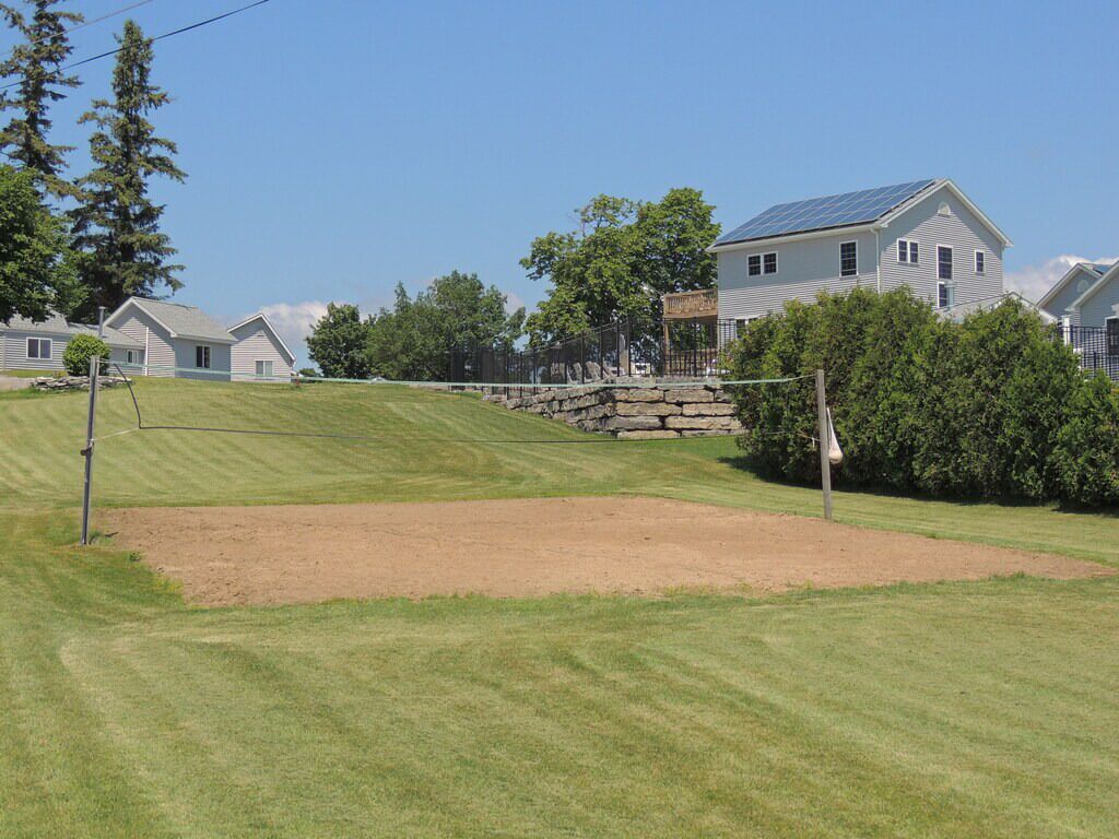 A residential area with houses, a stone bridge, and a well-maintained lawn.