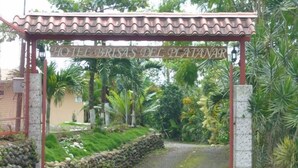 Un camino que lleva a la entrada de un hotel, con un letrero que dice "HOTEL BRISA DE PLATANAR".