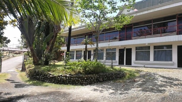 Un edificio de dos pisos con un jardín de pared de piedra en la fachada.