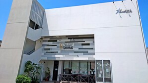 Een modern gebouw met een bord voor 'Lemon & Garlic Restaurant' en een bord met 'Sour&B'.