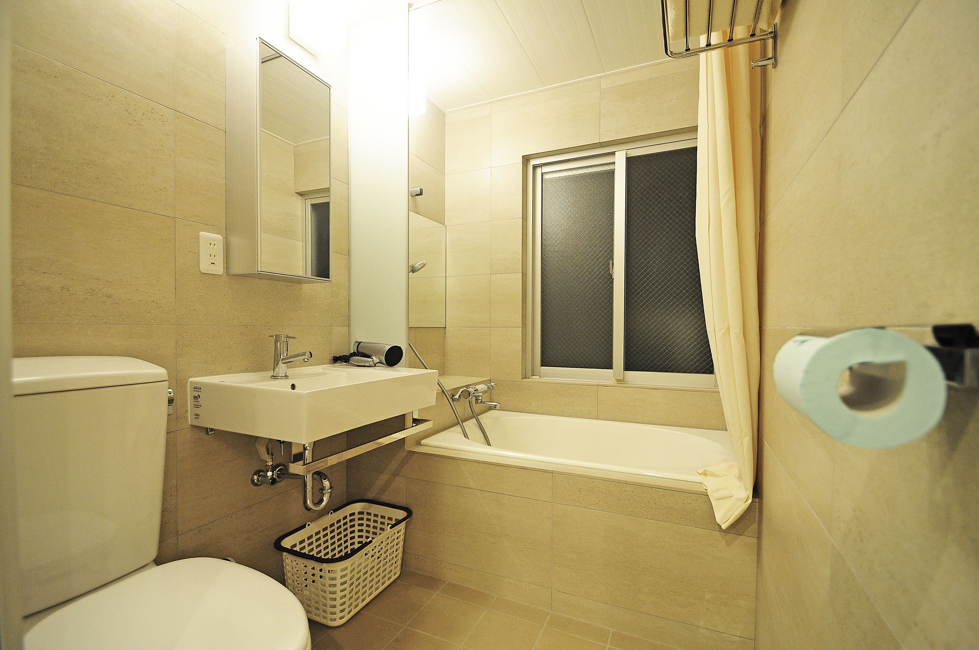 A bathroom with a toilet, sink, and bathtub.