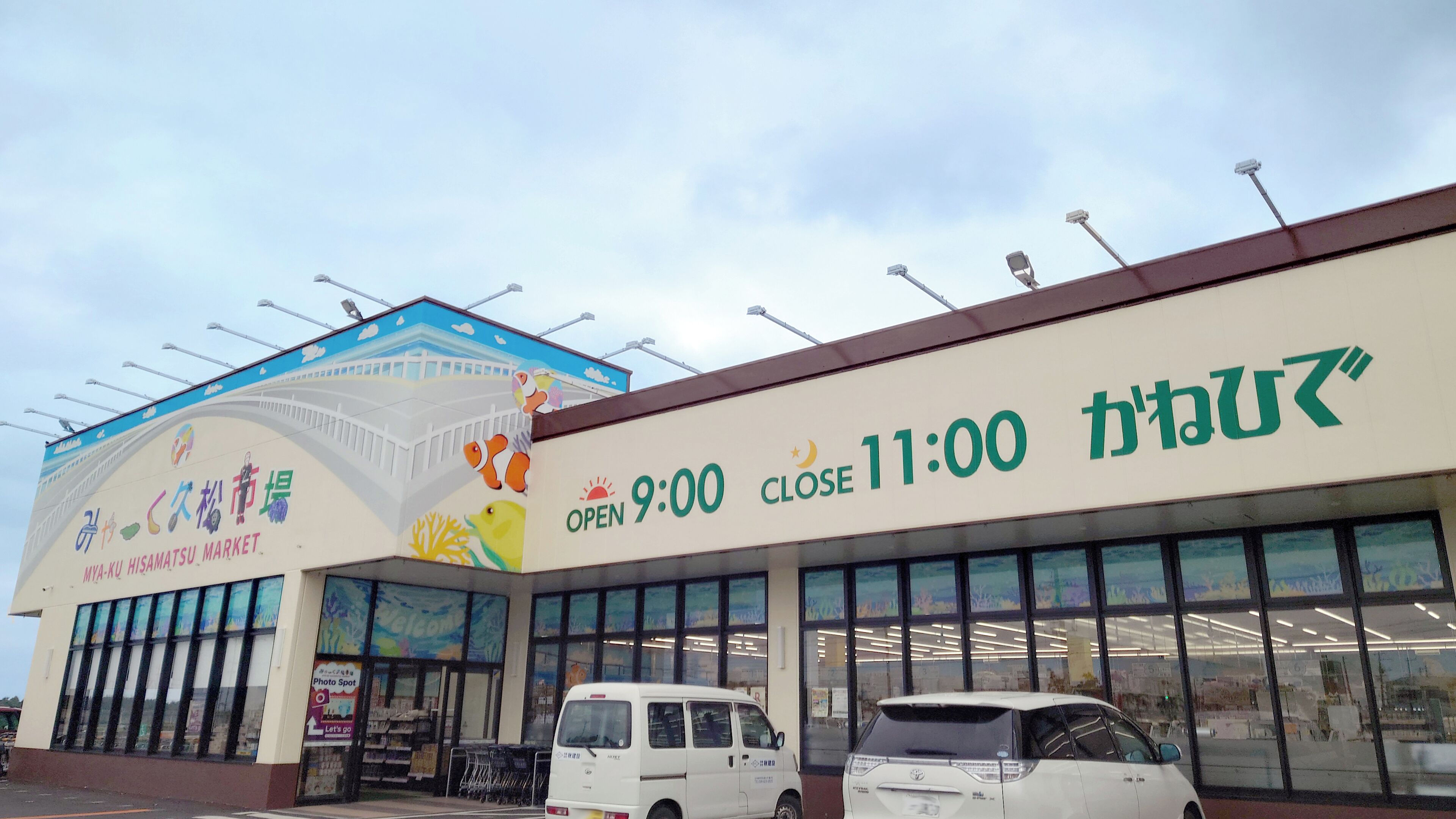 Un bâtiment abritant un marché, avec une enseigne indiquant qu’il ouvre à 9h00 et ferme à 23h00.