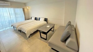 Een moderne hotelkamer met een groot bed, een bank en een kleine tafel.