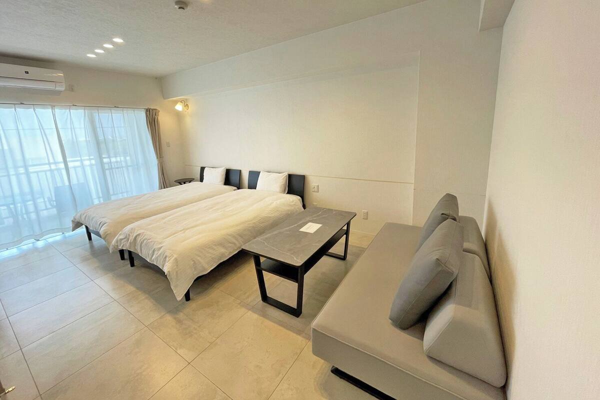 Une chambre d’hôtel moderne avec un grand lit, un canapé et une petite table.