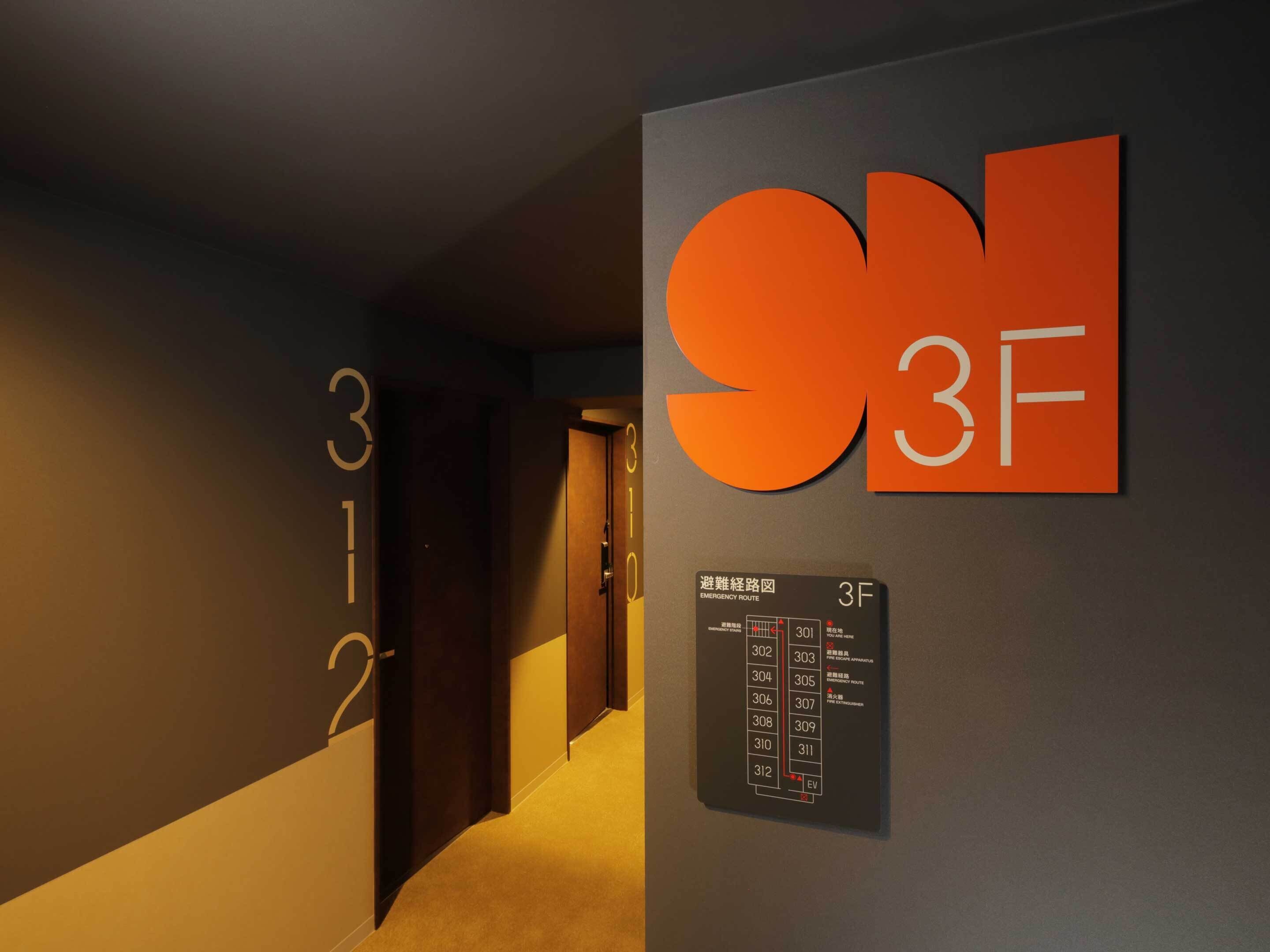 A hallway with a sign indicating room number 312 and a large orange '3F' sign above it.