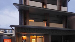 Un edificio moderno con una entrada destacada, un cartel visible que dice 'SMART PLACE NN' y un camino de entrada con portones.