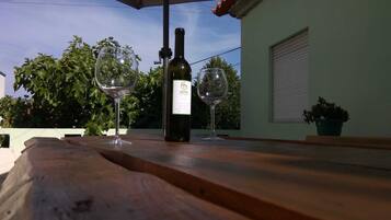 Enjoy a romantic dinner for two in this serene outdoor dining area, complete with a wine table setting.