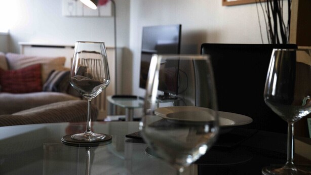 A living room with a glass table, a sofa, and a TV.