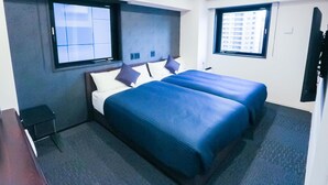 A hotel room with two beds, a desk, and a TV. - Hotel Livemax Tokyoshintomicho (Tokyo)