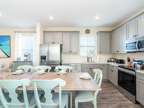 Enjoy cooking in this well-equipped kitchen with a central island, stainless steel appliances, and a dining area.
