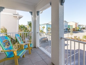 Relax in style with two Adirondack chairs on this balcony overlooking a charming residential street.