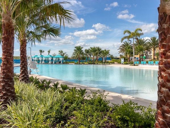 Relax by the serene pool surrounded by lush palm trees and tropical vegetation.