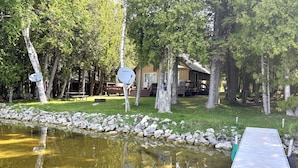 A lakeside property with a dock, a pond, and a cabin surrounded by trees. - The House that Jack Built (Moran)