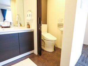 A bathroom with a toilet, a sink, and a mirror.