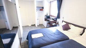 A hotel room with a bed, a desk, a chair, and a television.