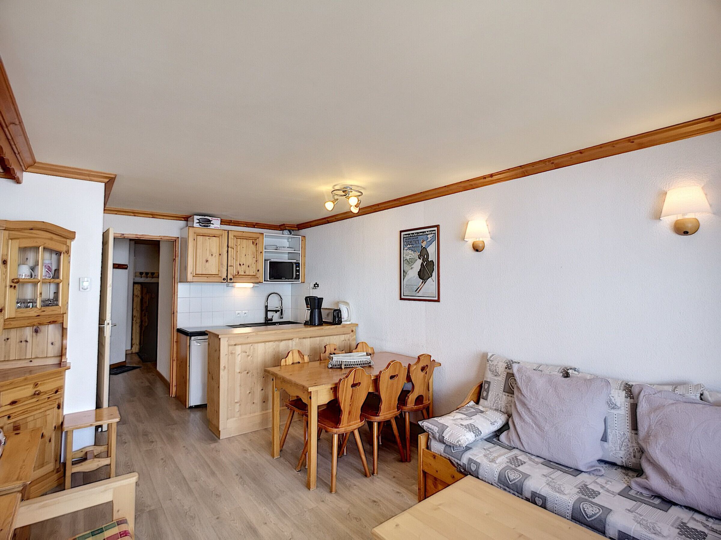 Un espace de vie compact comprenant un coin cuisine, des meubles en bois et un canapé.