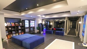 A modern lobby with a seating area, vending machines, and a TV screen. - HOTEL LiVEMAX Tokyo-Otsuka Ekimae (Tokyo)