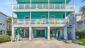 A two-story building with a balcony, numbered 16, featuring a covered entrance and outdoor seating. - Coastal Tybee House & Bungalow : Steps from Beach (Tybee Island)