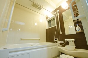A modern bathroom with a bathtub, a sink, a mirror, and a shower. - Kawabata (Kyoto)