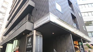 Ein moderner Hotel Eingang mit einem auffälligen Schild für Hotel Livemax.