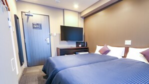 Ein Hotelzimmer mit zwei Betten, einem an der Wand befestigten Fernseher und einer Tür mit einem Schild.