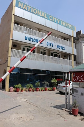 A building labeled 'National City Hotel' with a balcony and potted plants.