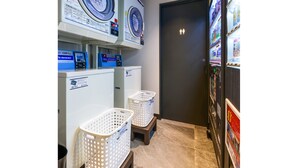 A laundry facility with two washing machines, a dryer, and a vending machine. - HOTEL LiVEMAX AKASAKA (Tokyo)