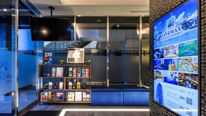 A modern hotel lobby with a digital display, a reception desk, and a seating area. - HOTEL LiVEMAX AKASAKA (Tokyo)