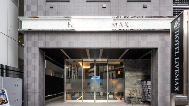The entrance to a hotel with a tiled facade, a glass door entrance, and a sign indicating the hotel name. - HOTEL LiVEMAX AKASAKA (Tokyo)