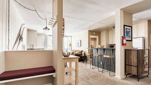 Ein modernes Interieur mit einer Bank, einem Holztisch und einer Bar mit Hockern.
