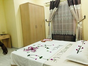A bedroom with a bed, a wardrobe, a desk, and a window with curtains. - Clove Beach (Feydhoo)